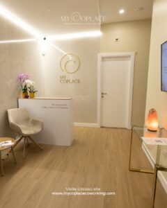 Receção do My Coplace na Maia, com o logótipo dourado na parede, orquídeas e uma cadeira